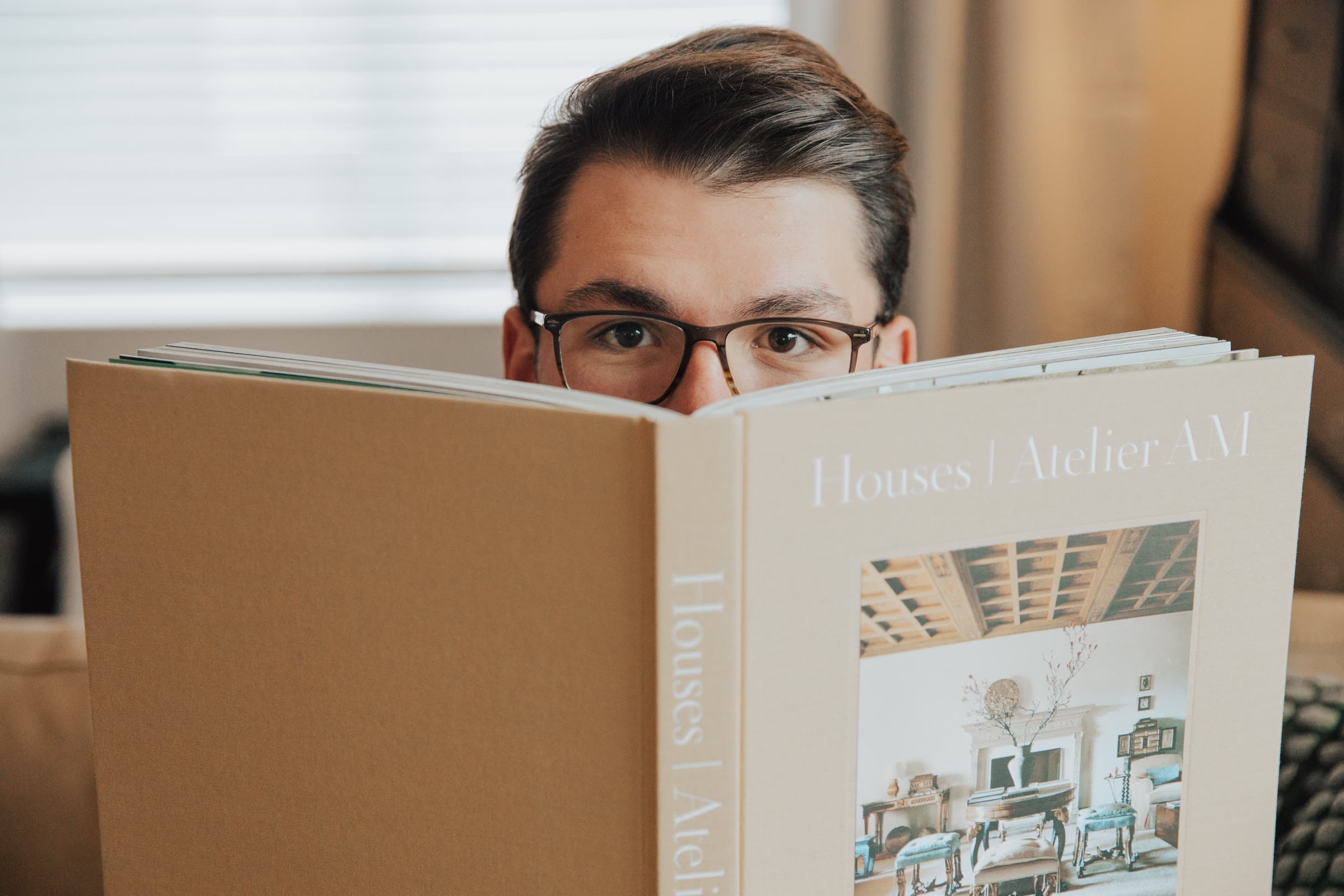 Austin Sizemore peeking over an interiors book